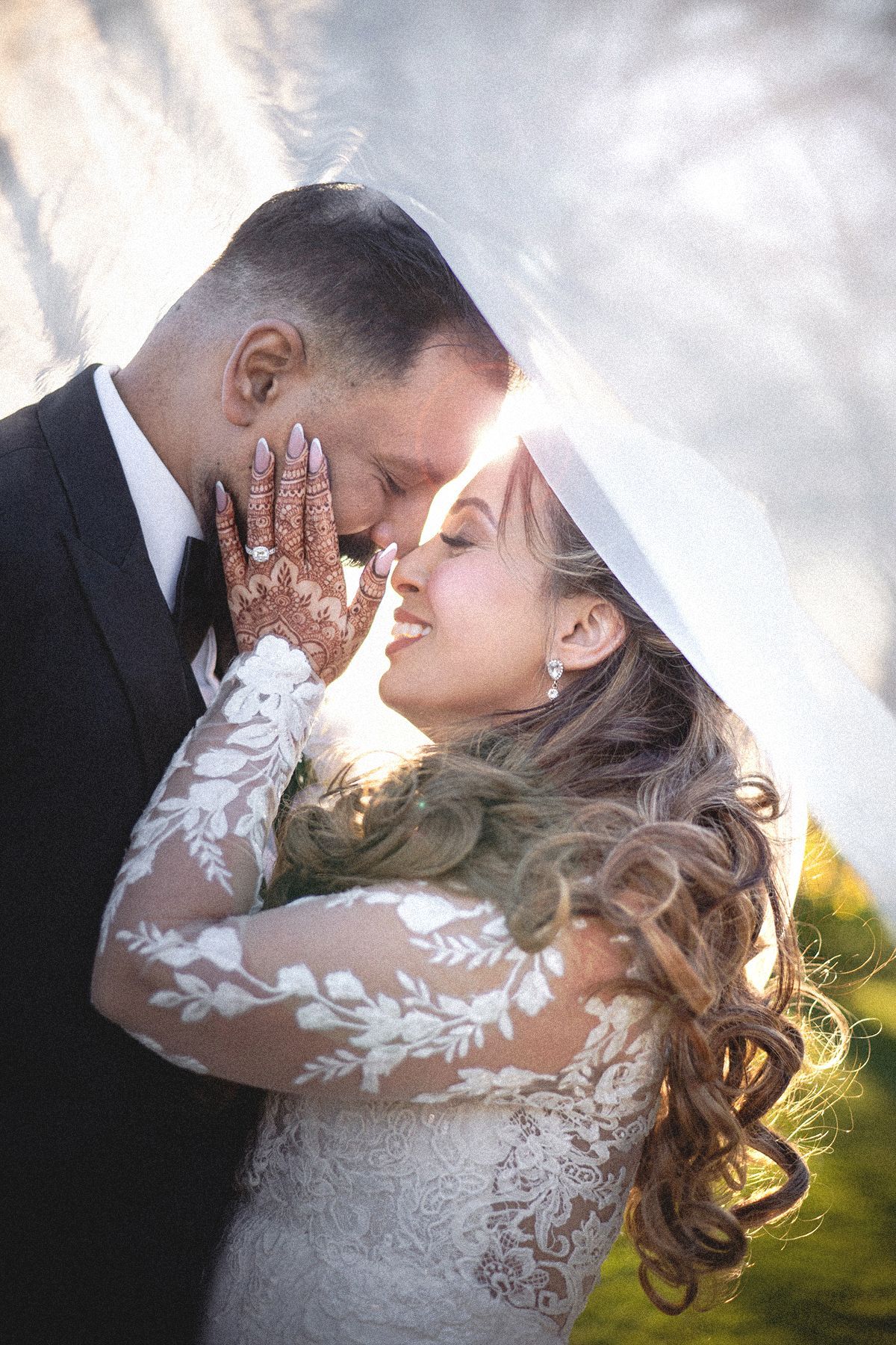 Bride and groom portrait taken under the veil and back-lit at golden hour.
