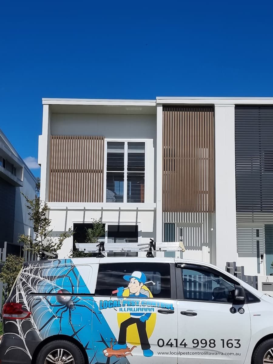 A White Van Is Parked In Front Of A Large White Building — Local Pest Control Illawarra in Horsley, NSW
