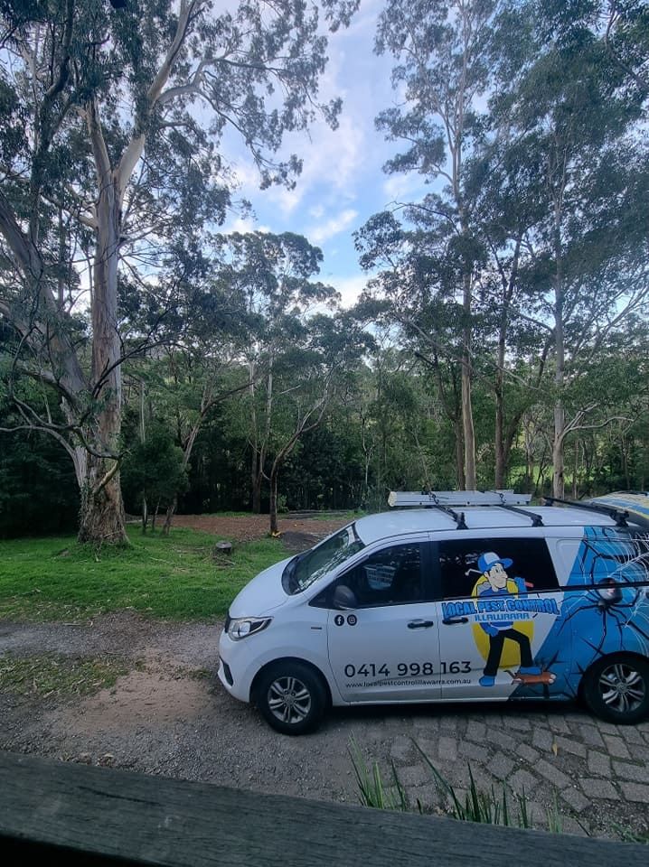 A White Van Is Parked In A Park With Trees In The Background — Local Pest Control Illawarra in Horsley, NSW