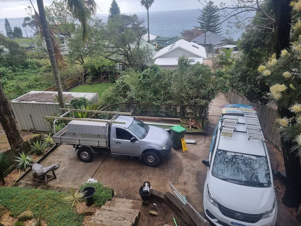 A Truck And A Van Are Parked In A Driveway With A View Of The Ocean — Local Pest Control Illawarra in Albion Park, NSW
