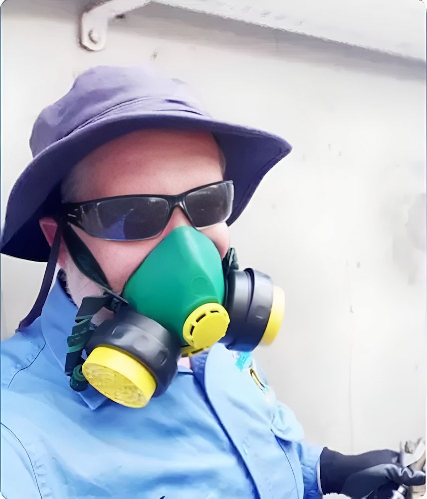 A Man Wearing A Hat And Sunglasses Is Wearing A Gas Mask — Local Pest Control Illawarra in Balgownie, NSW