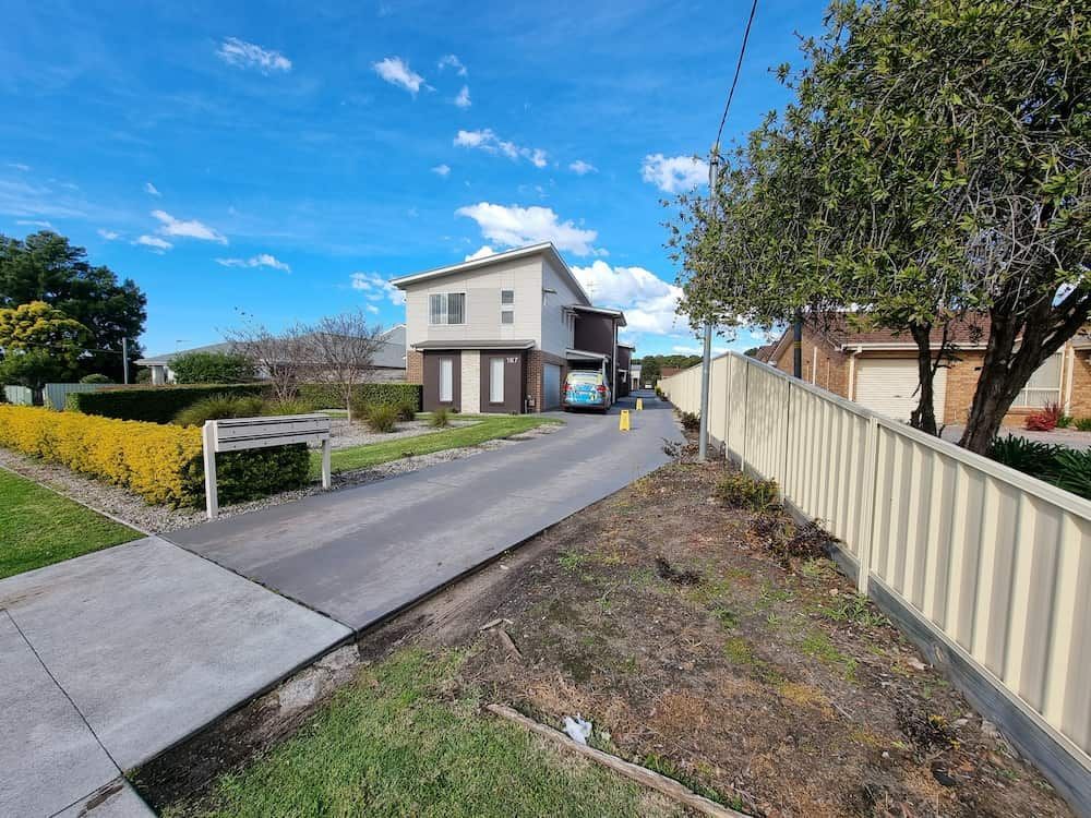 A House Is Sitting On The Side Of A Road Next To A Fence — Local Pest Control Illawarra in Figtree, NSW