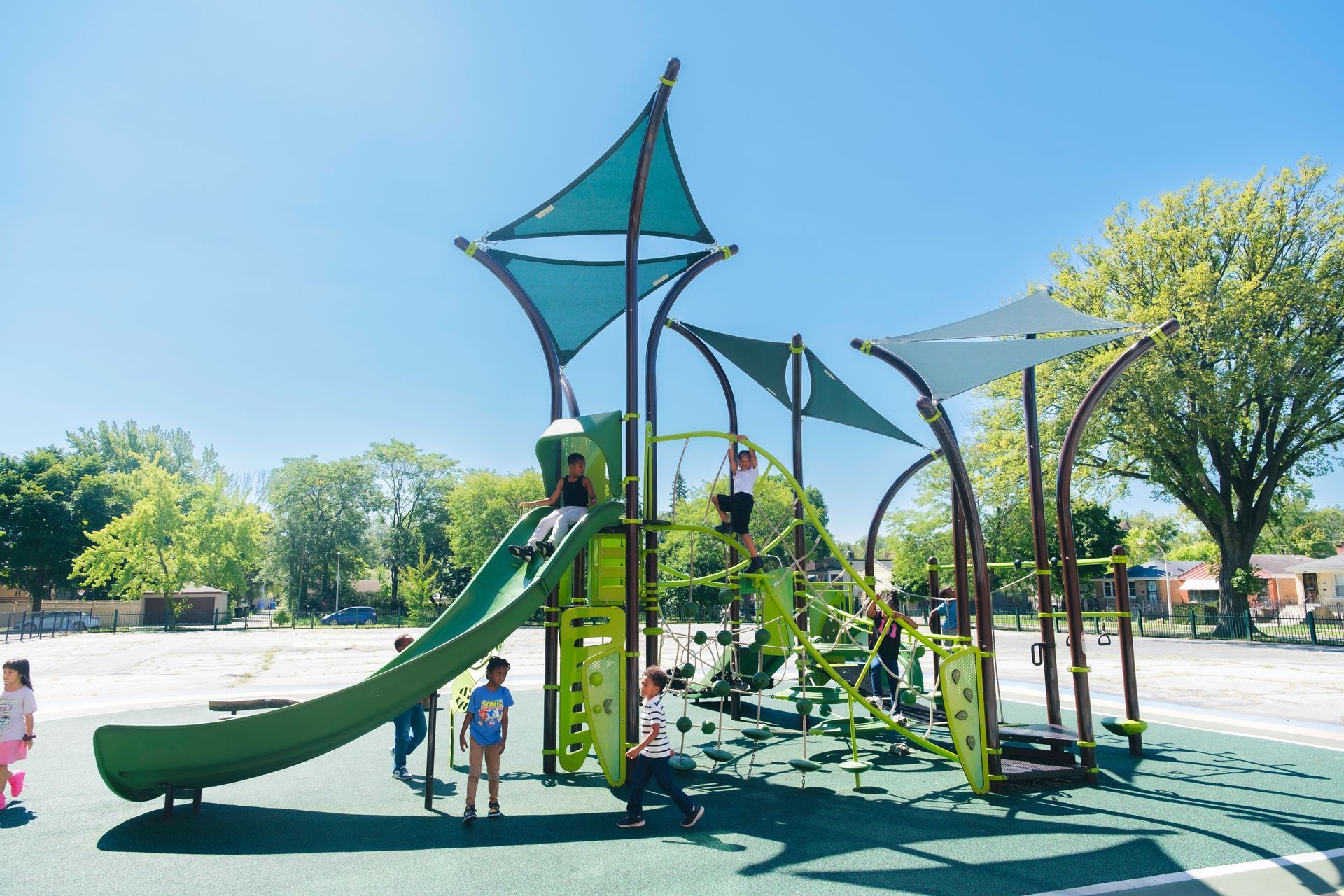 A group of Montessori children are playing on a playground in a park.