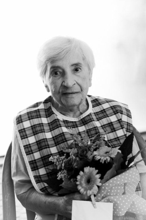 anziana con fiori in casa di riposo