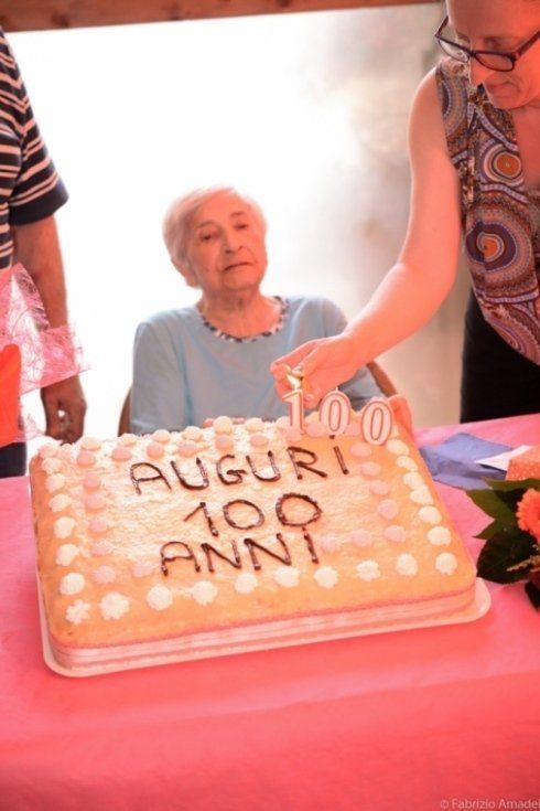 anziana con torta di compleanno per i suoi 100 anni