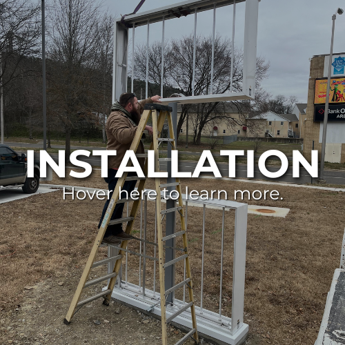 Man on a ladder installing a sign frame outdoors.  | commercial sign installation