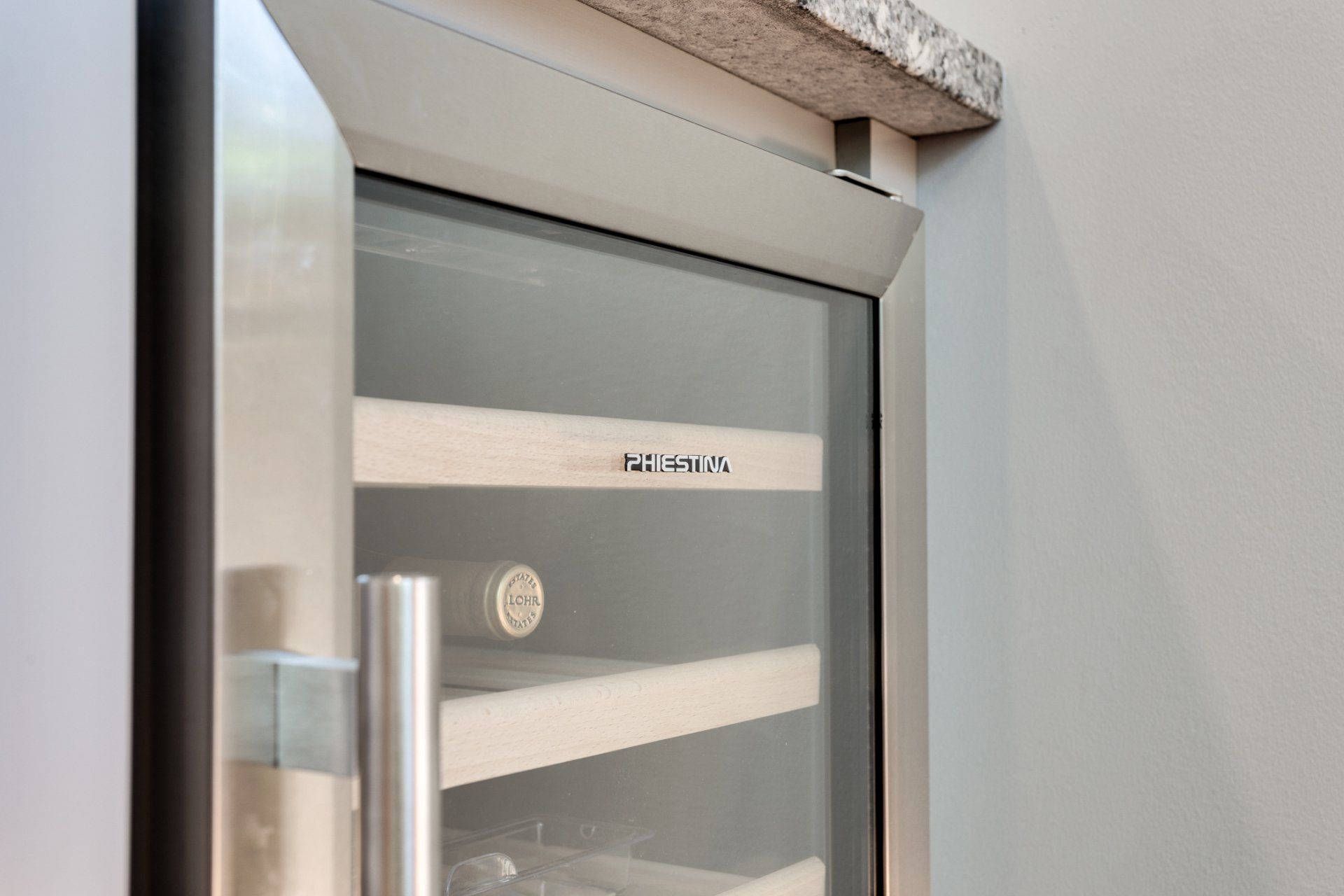 A stainless steel wine cooler with a glass door