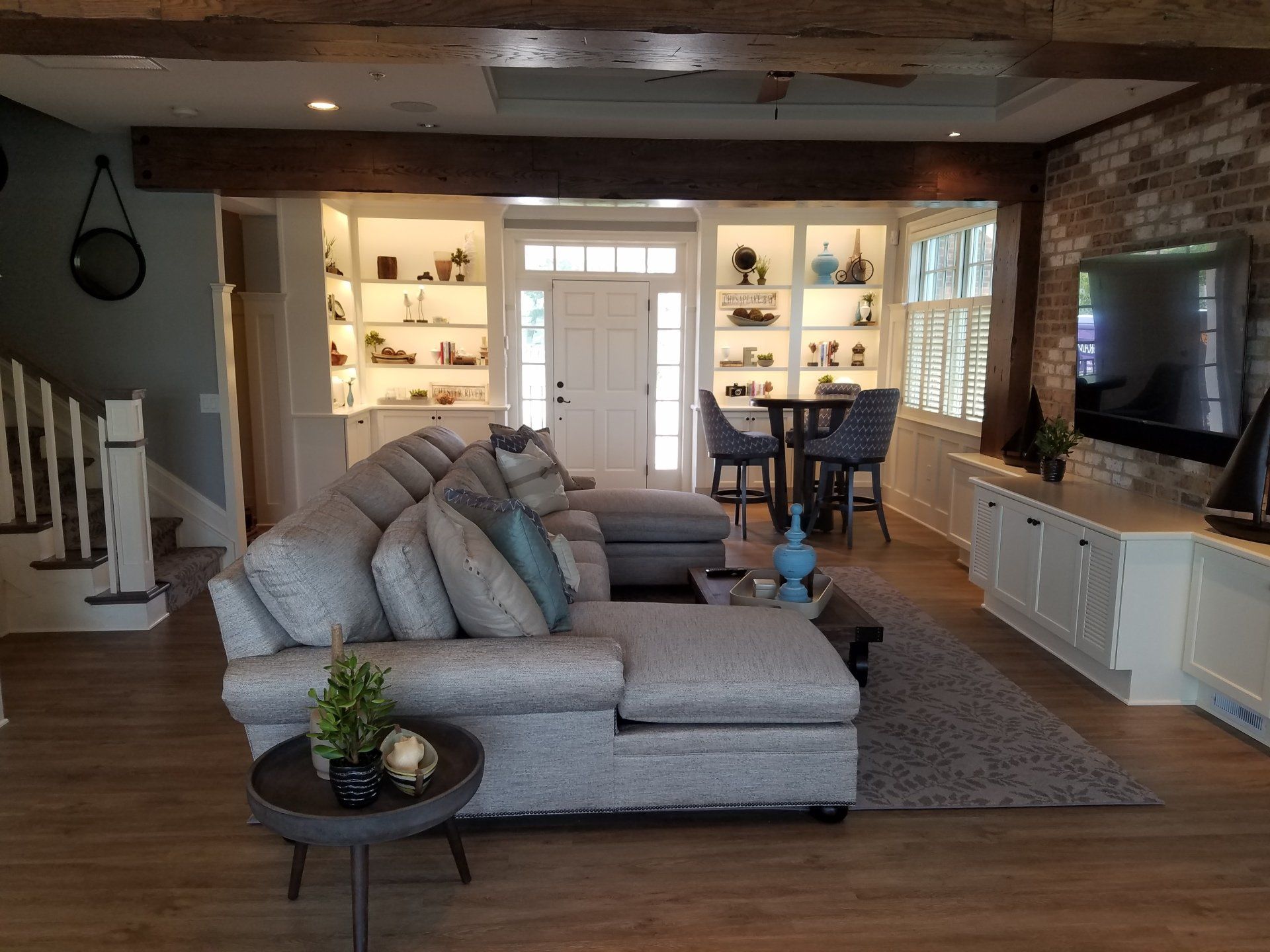 A living room with a large sectional couch and a flat screen tv.