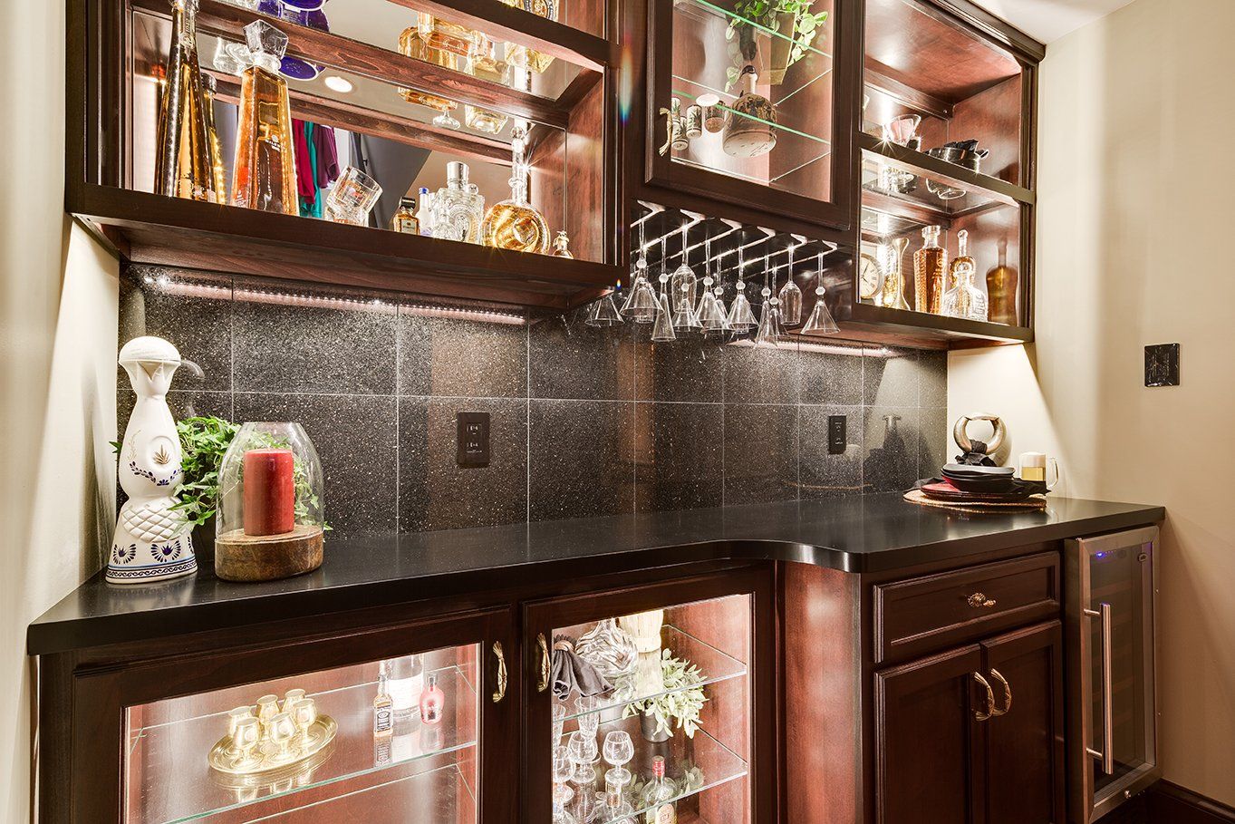 A bar with wine glasses and bottles on the shelves