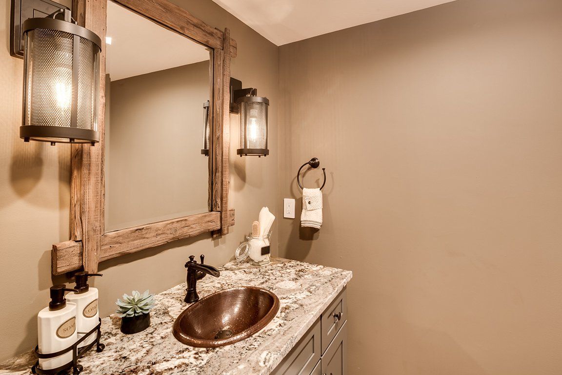 A bathroom with a sink , mirror , and light fixtures.