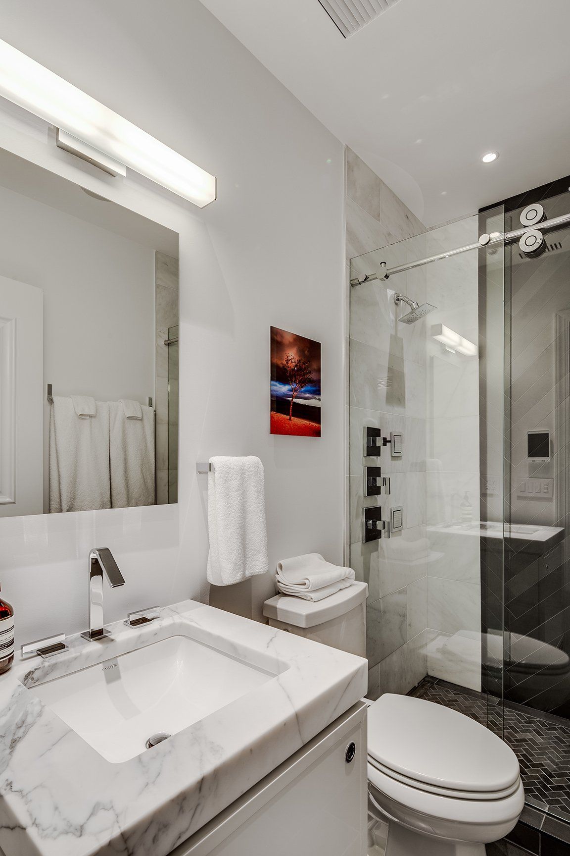A bathroom with a sink , toilet and shower.