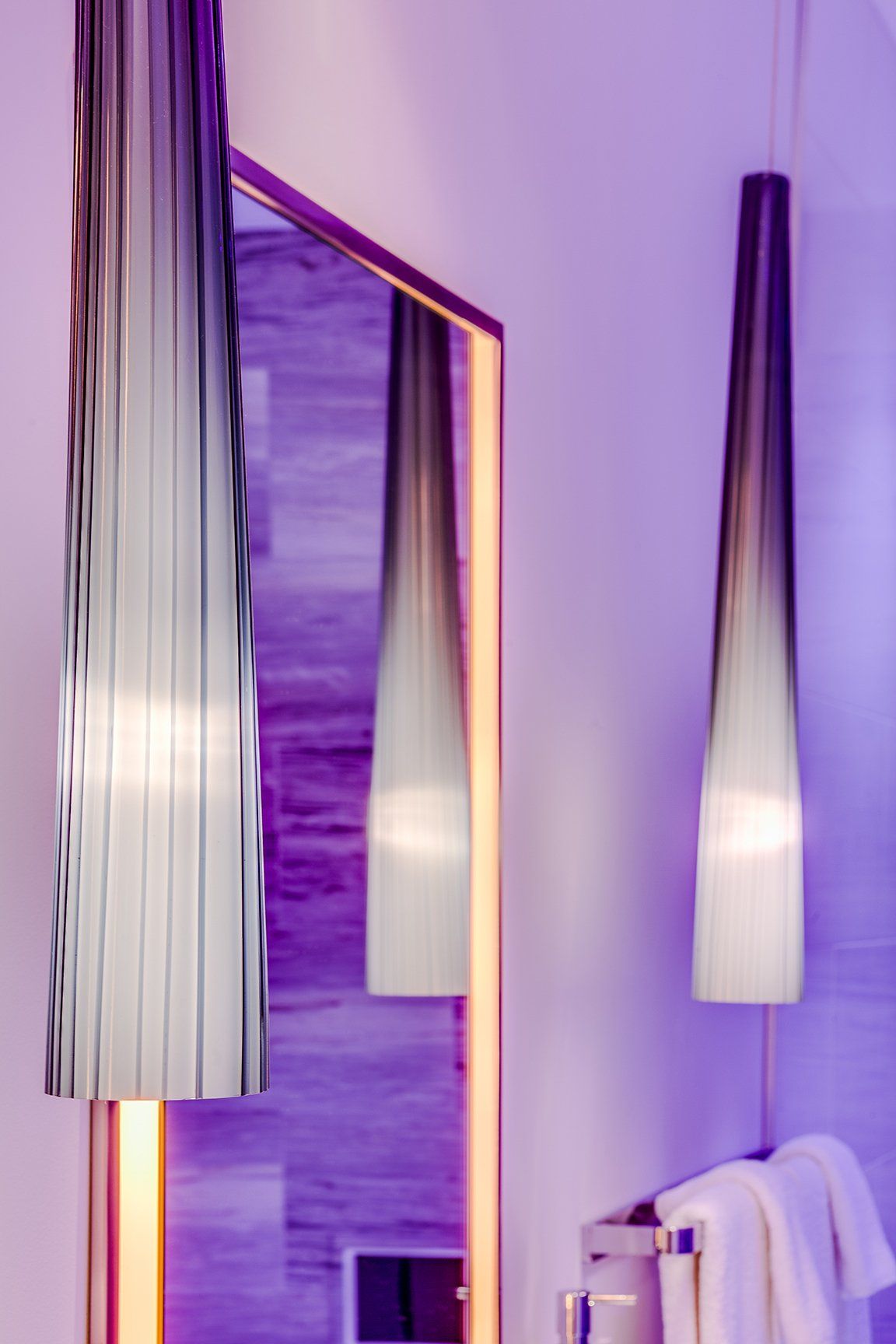 A bathroom with purple lights and a mirror