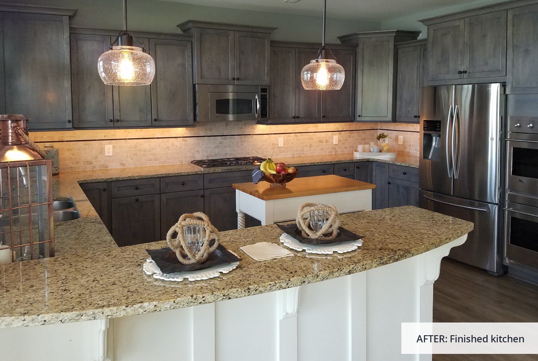 A kitchen with stainless steel appliances and granite counter tops.