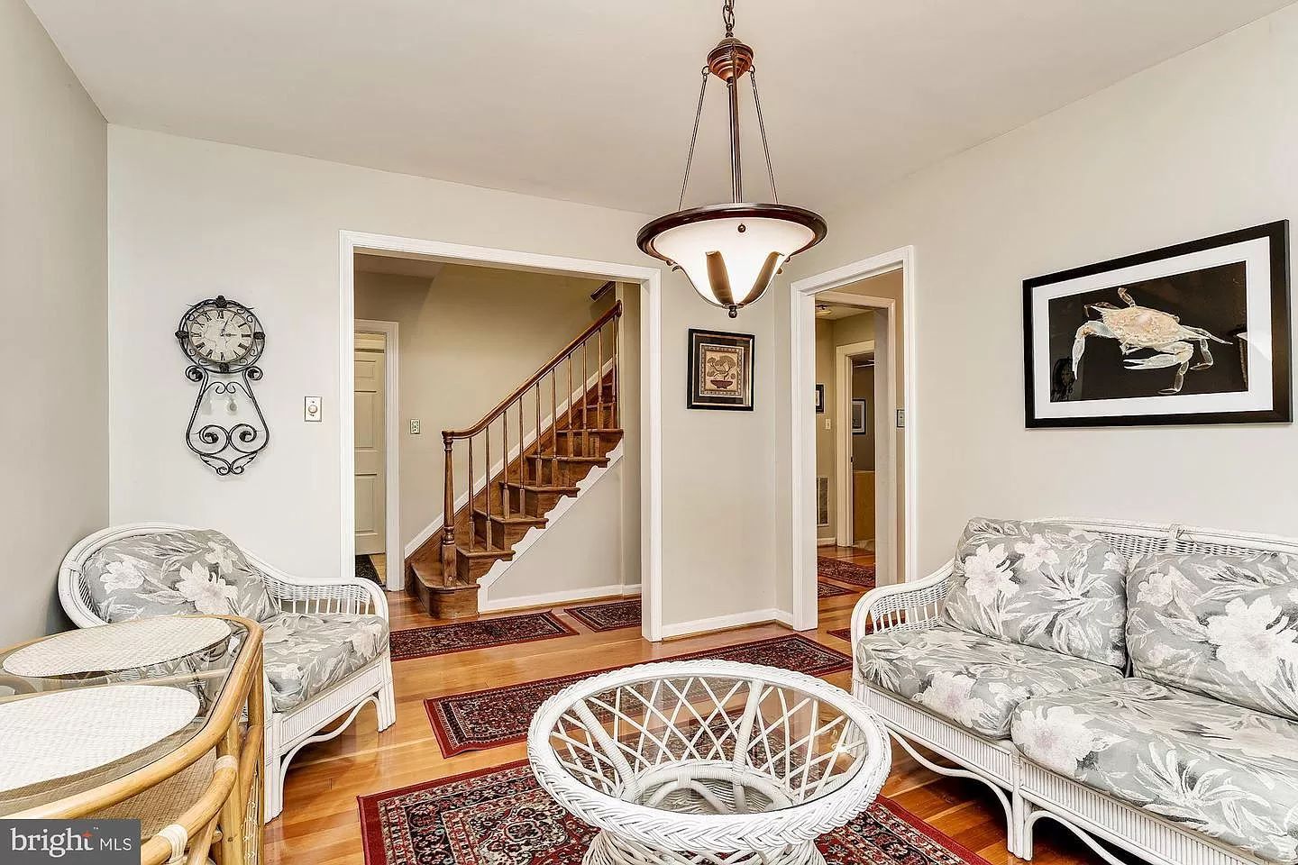 A living room with a couch , chair , table and stairs.