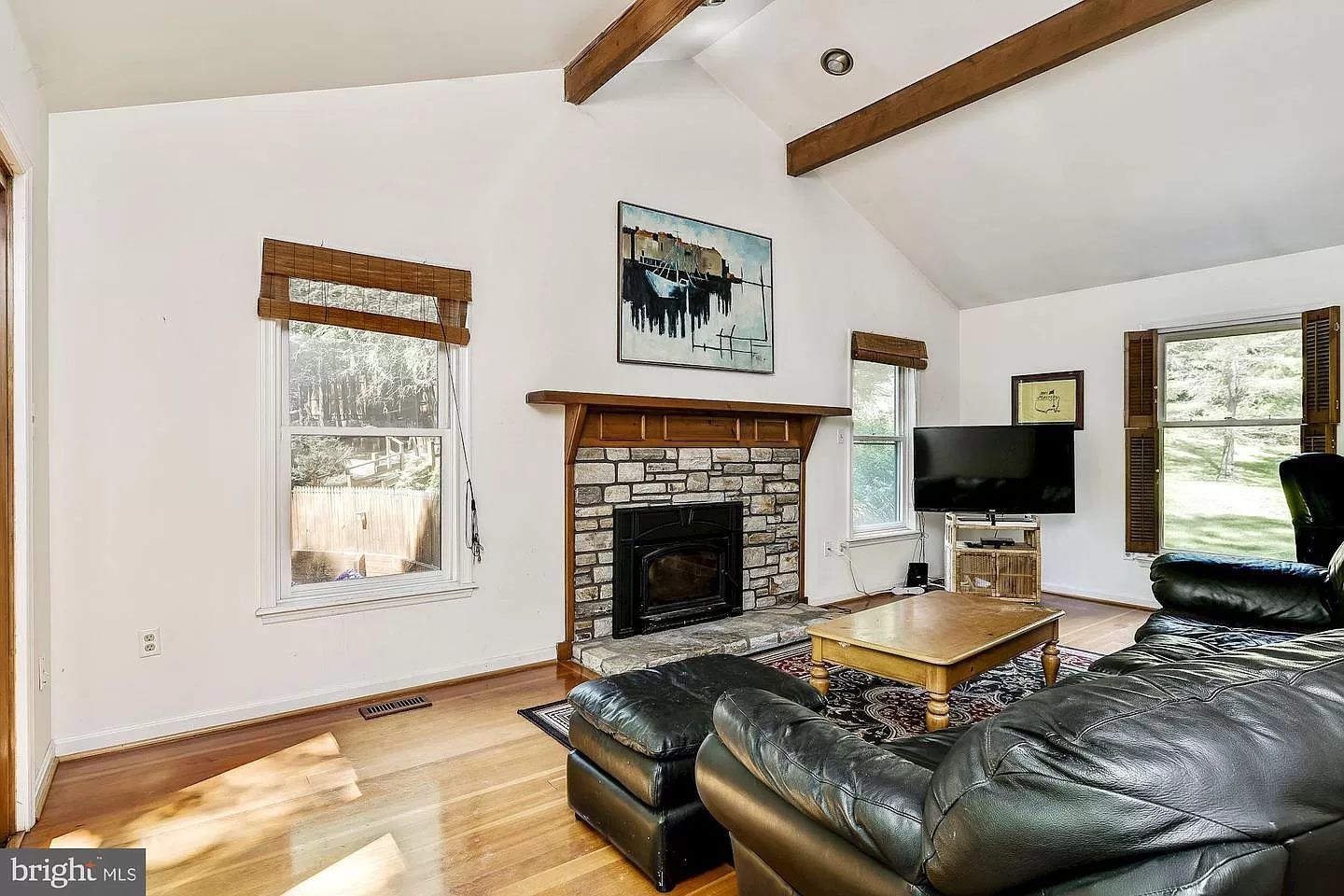 A living room with a fireplace , couch , and television.