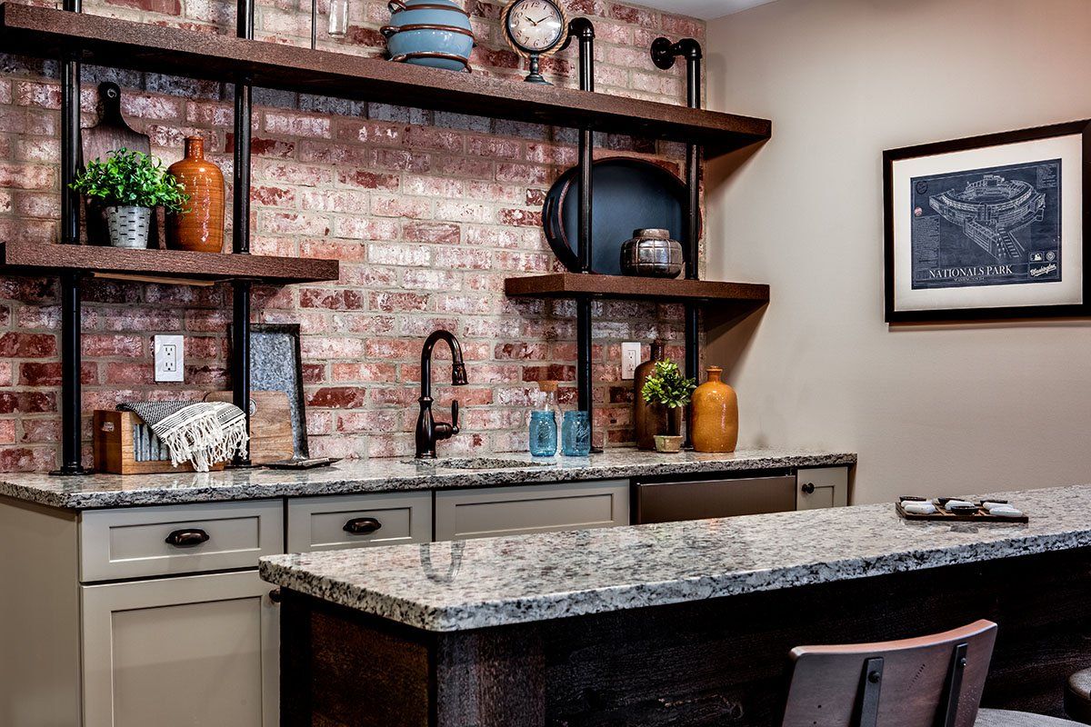 A kitchen with granite counter tops and a brick wall.