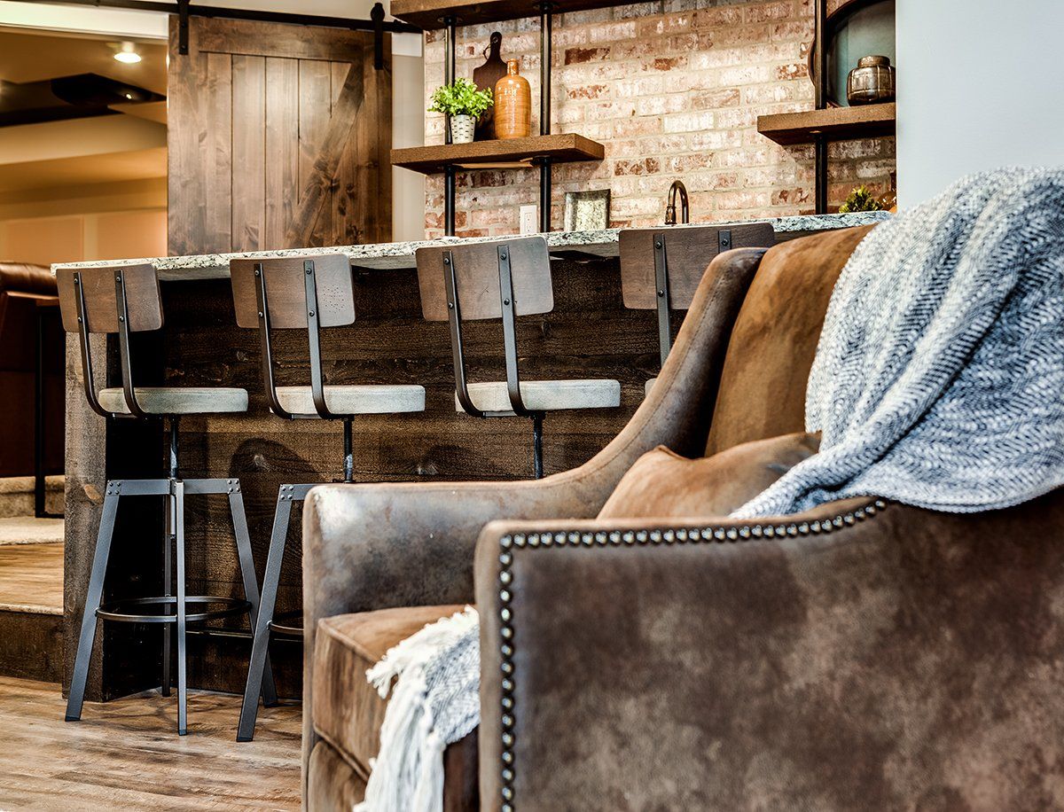 A chair with a blanket on it is in a living room next to a bar.