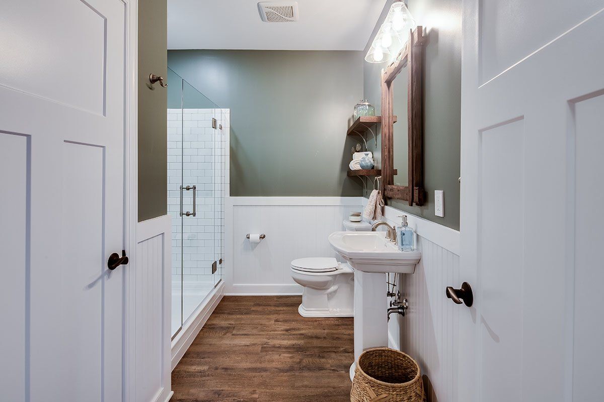 A bathroom with a toilet , sink , and mirror.