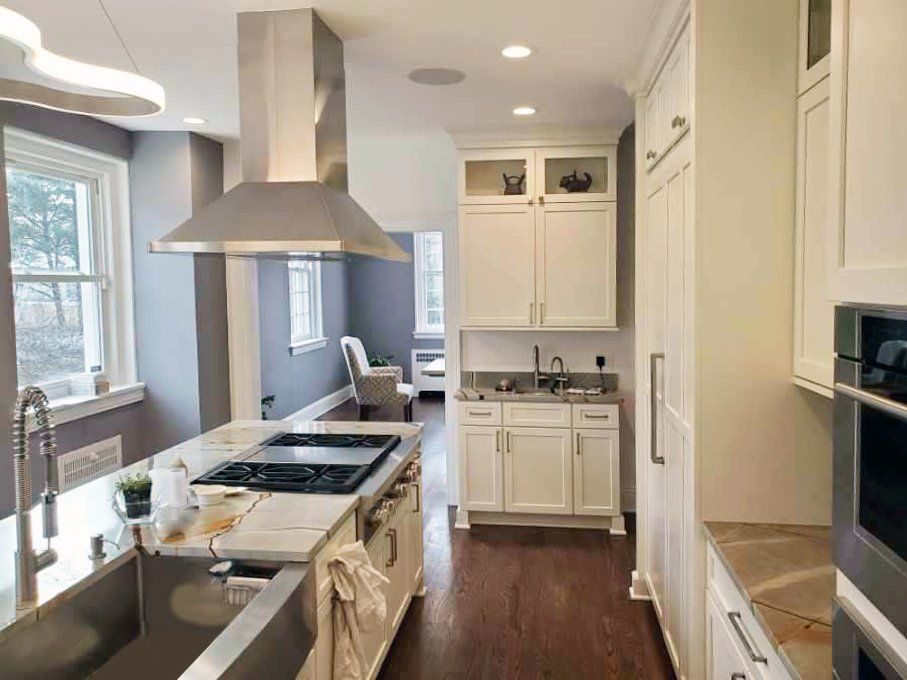 A kitchen with white cabinets and stainless steel appliances