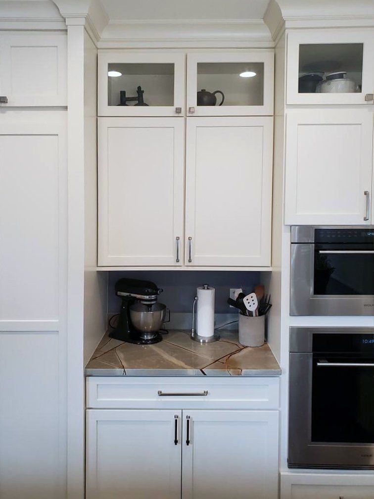 A kitchen with white cabinets and stainless steel appliances