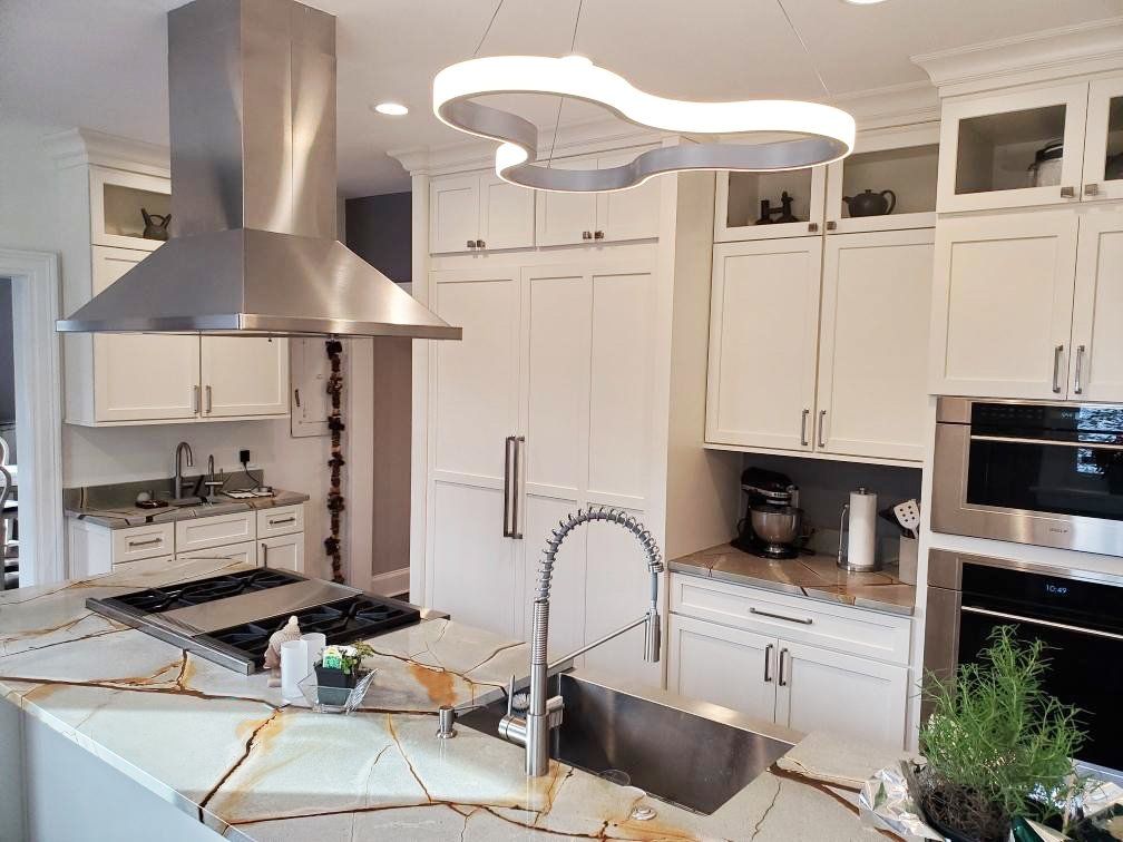A kitchen with white cabinets and stainless steel appliances