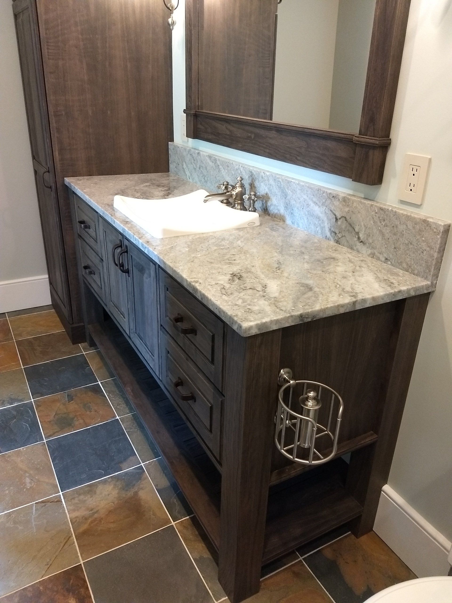 A bathroom with a sink , mirror , and tile floor.