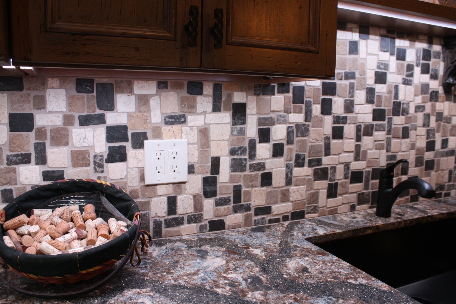 A basket of wine corks sits on a kitchen counter next to a sink.