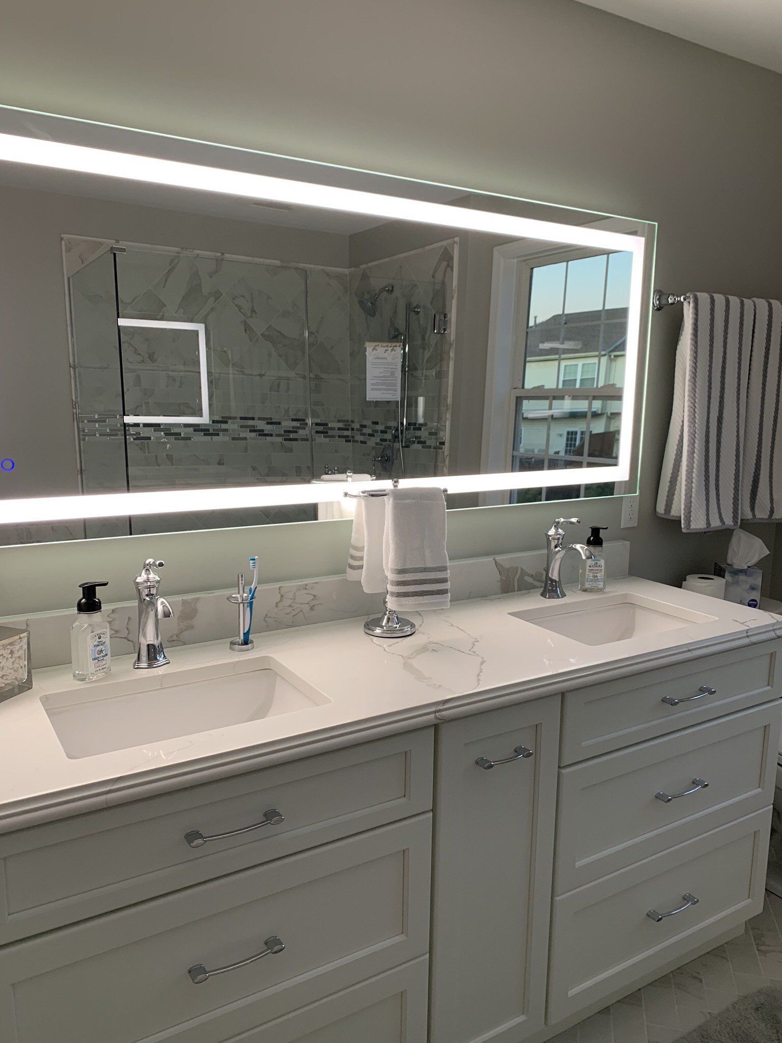 A bathroom with two sinks and a large mirror.
