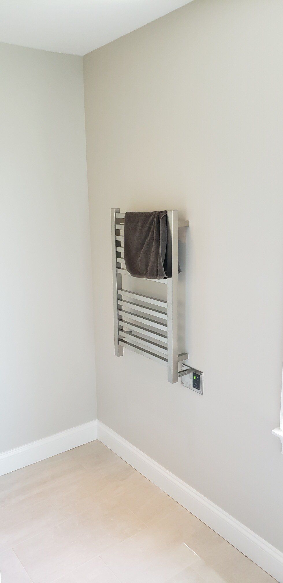 A towel rack is hanging on a wall in a bathroom.
