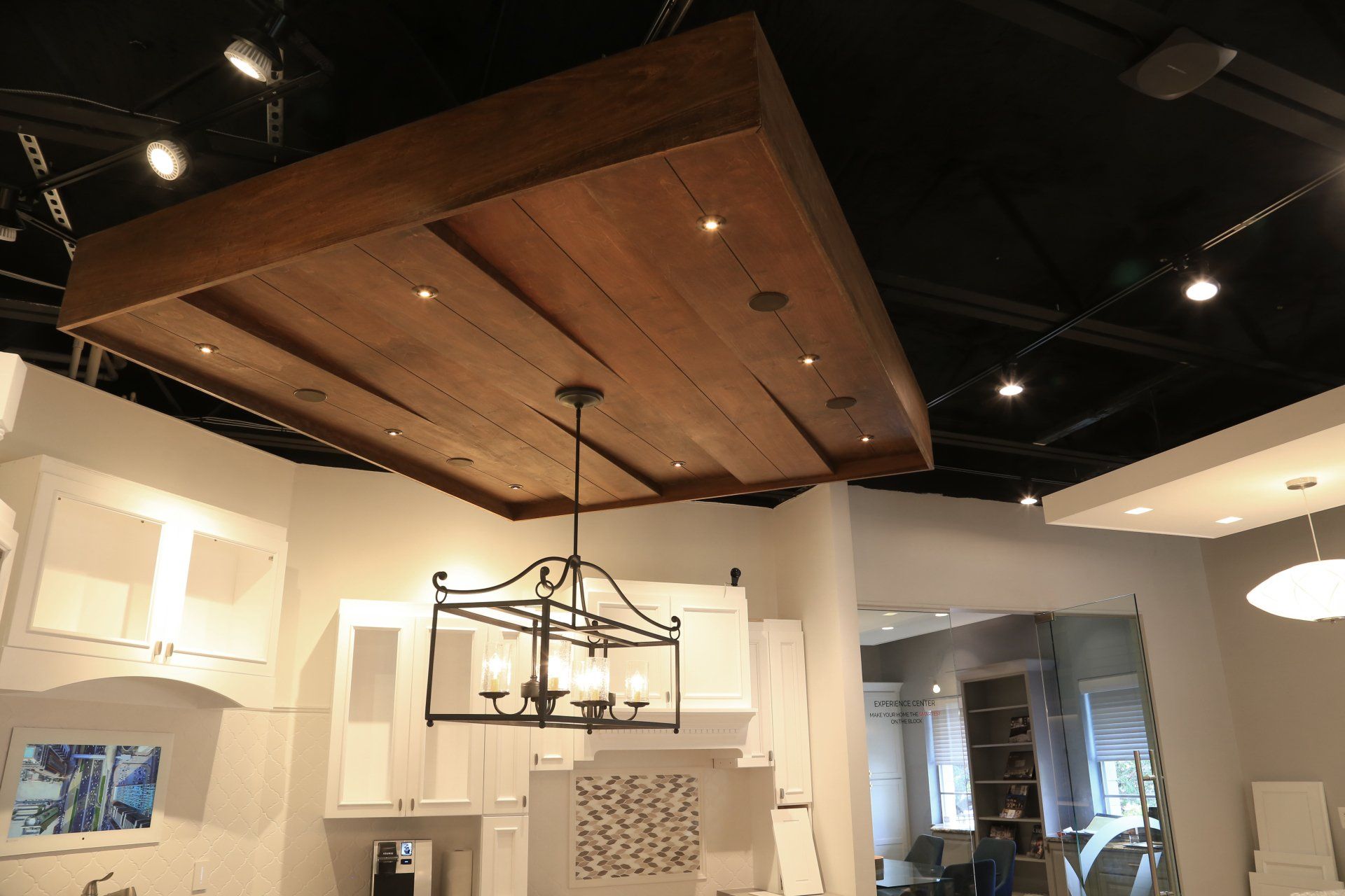 A kitchen with white cabinets and a wooden ceiling
