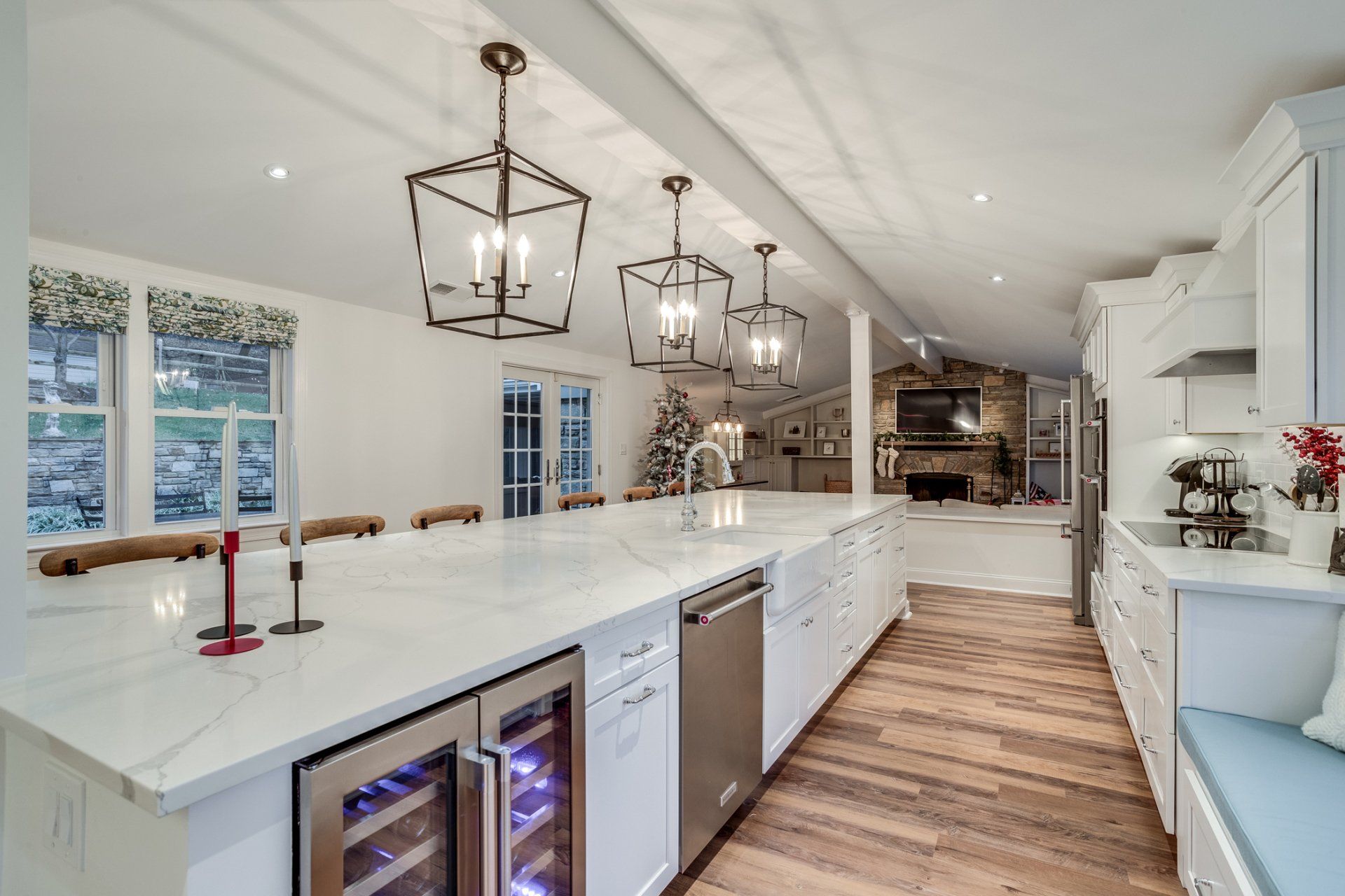 A kitchen with white cabinets , stainless steel appliances and a wine cooler.