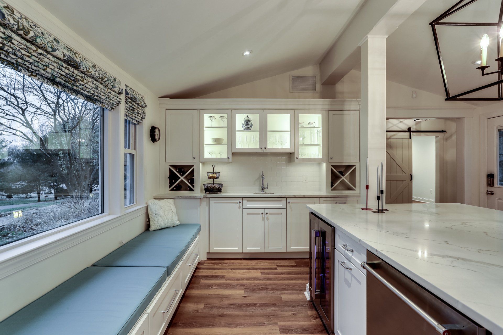 A kitchen with white cabinets and a large island