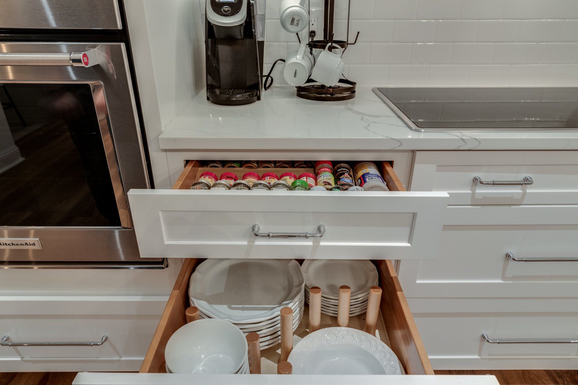 A kitchen with a drawer filled with plates and utensils.