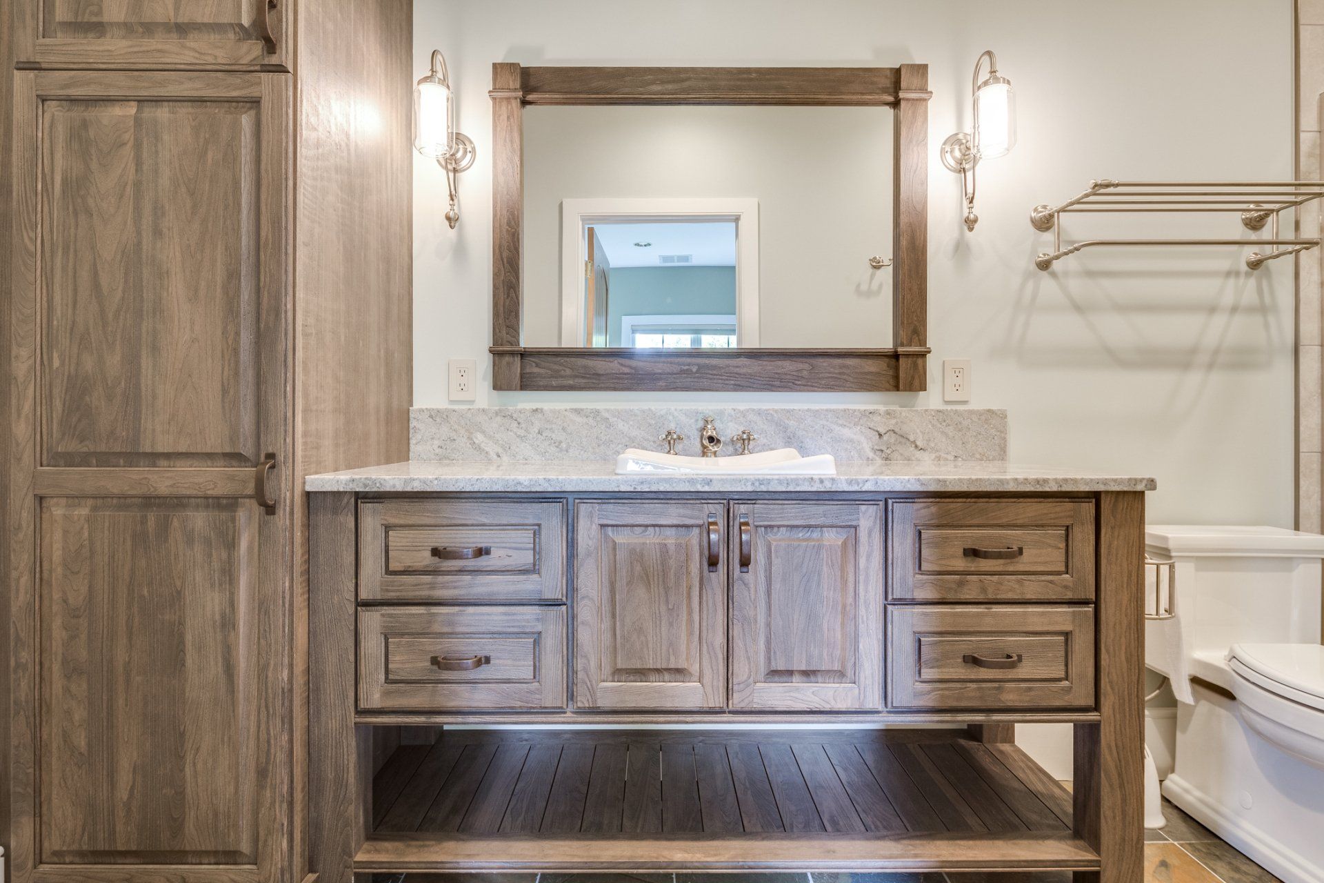 A bathroom with a sink , mirror and cabinets.