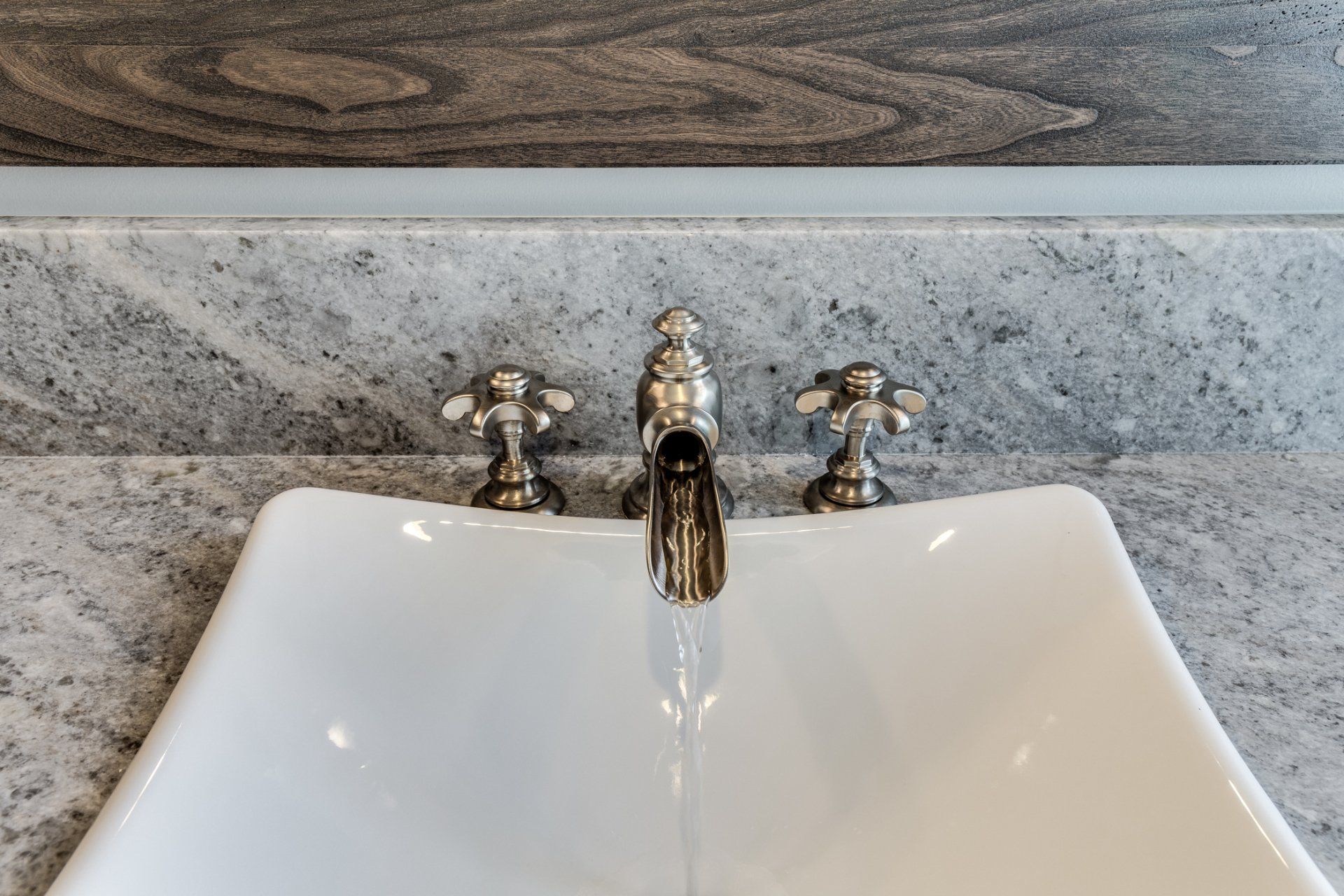 A bathroom sink with a faucet and water running out of it.