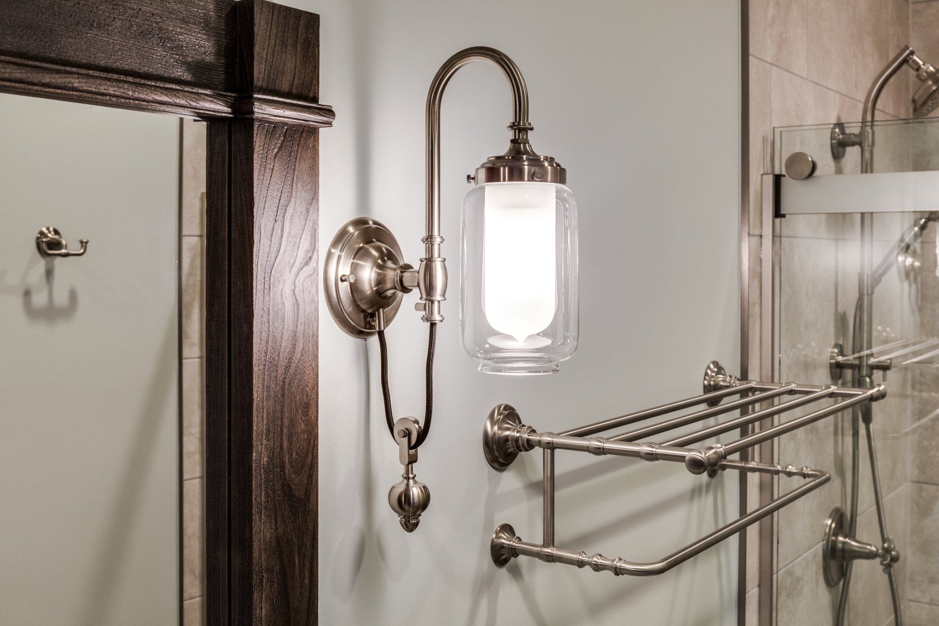 A bathroom with a towel rack and a light on the wall.