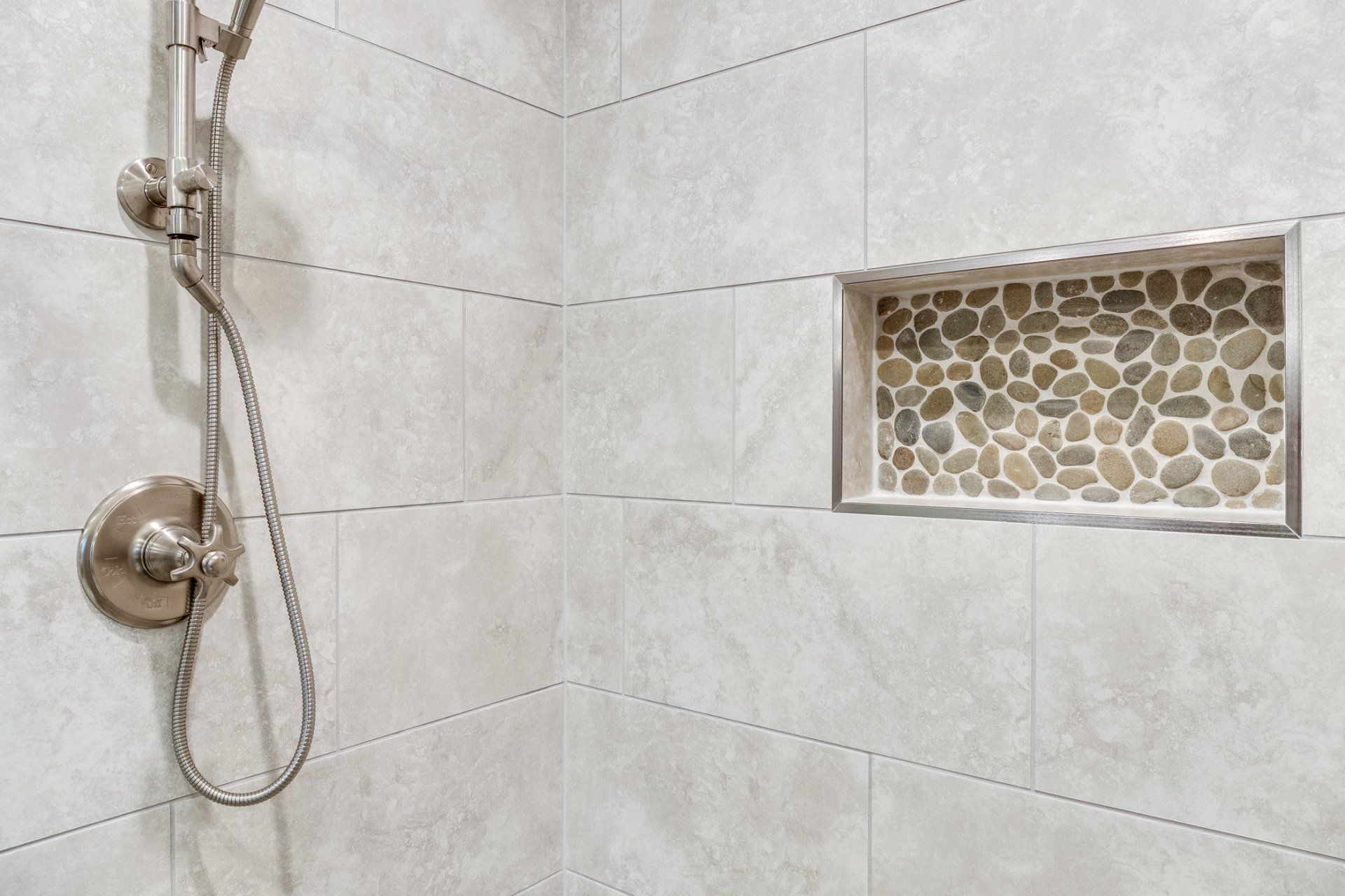 A shower with a stone niche and a shower head.