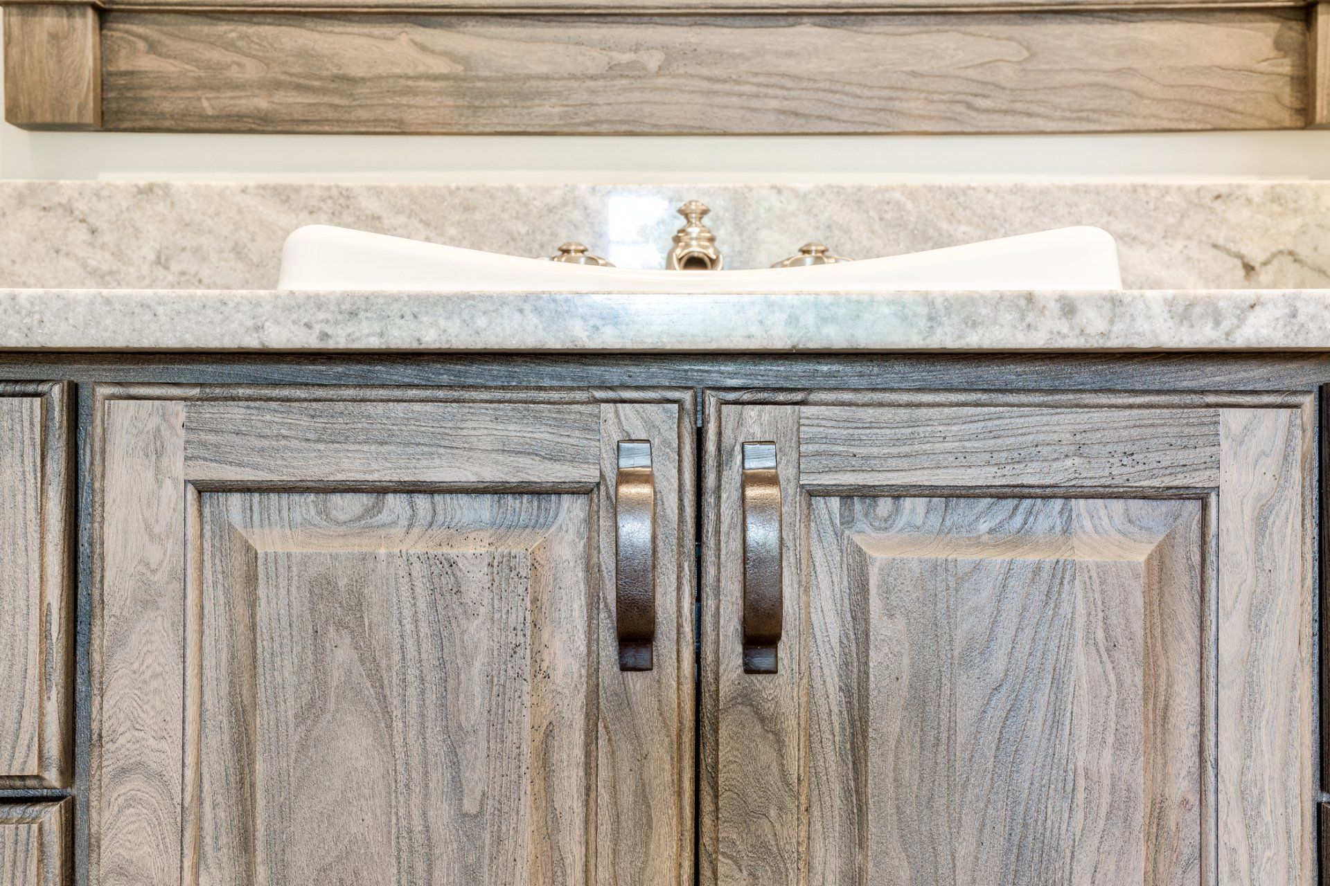 A bathroom sink with wooden cabinets and a granite counter top.