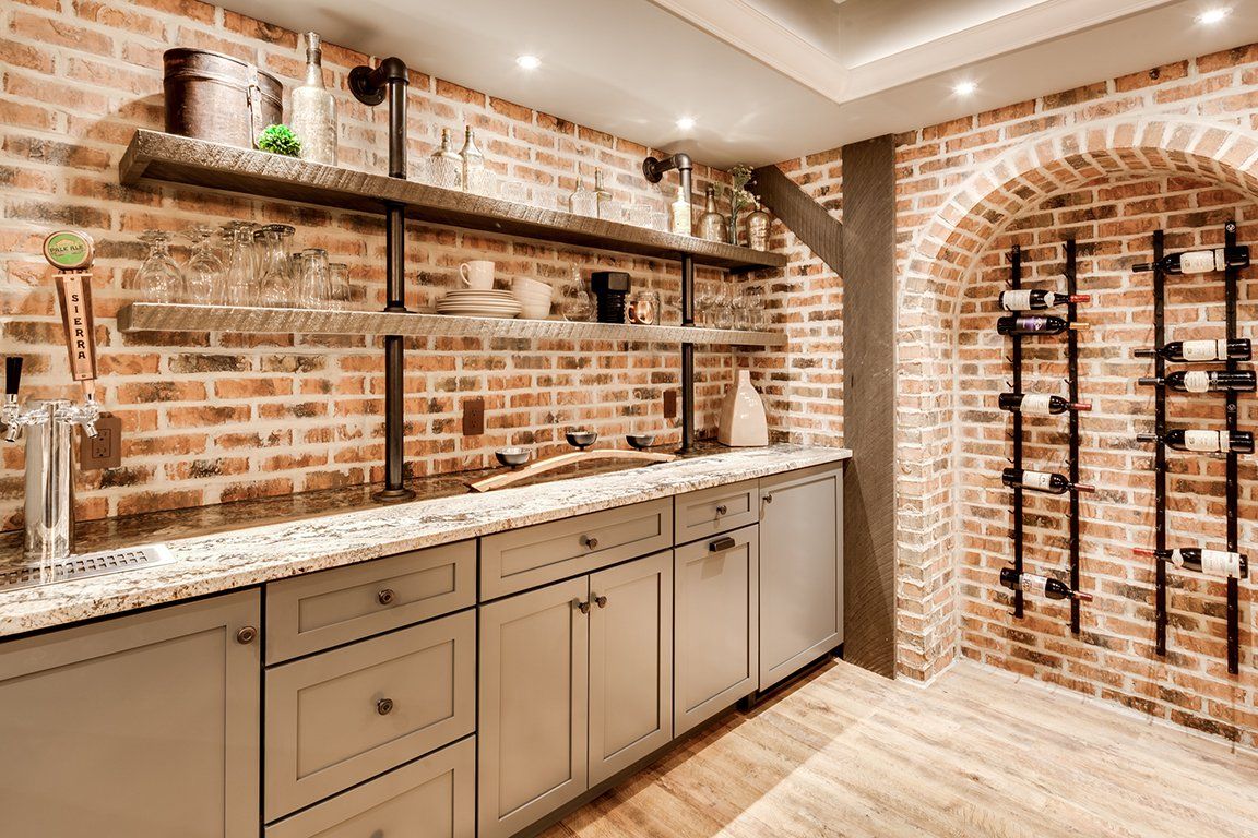 A kitchen with a brick wall and a wine rack.