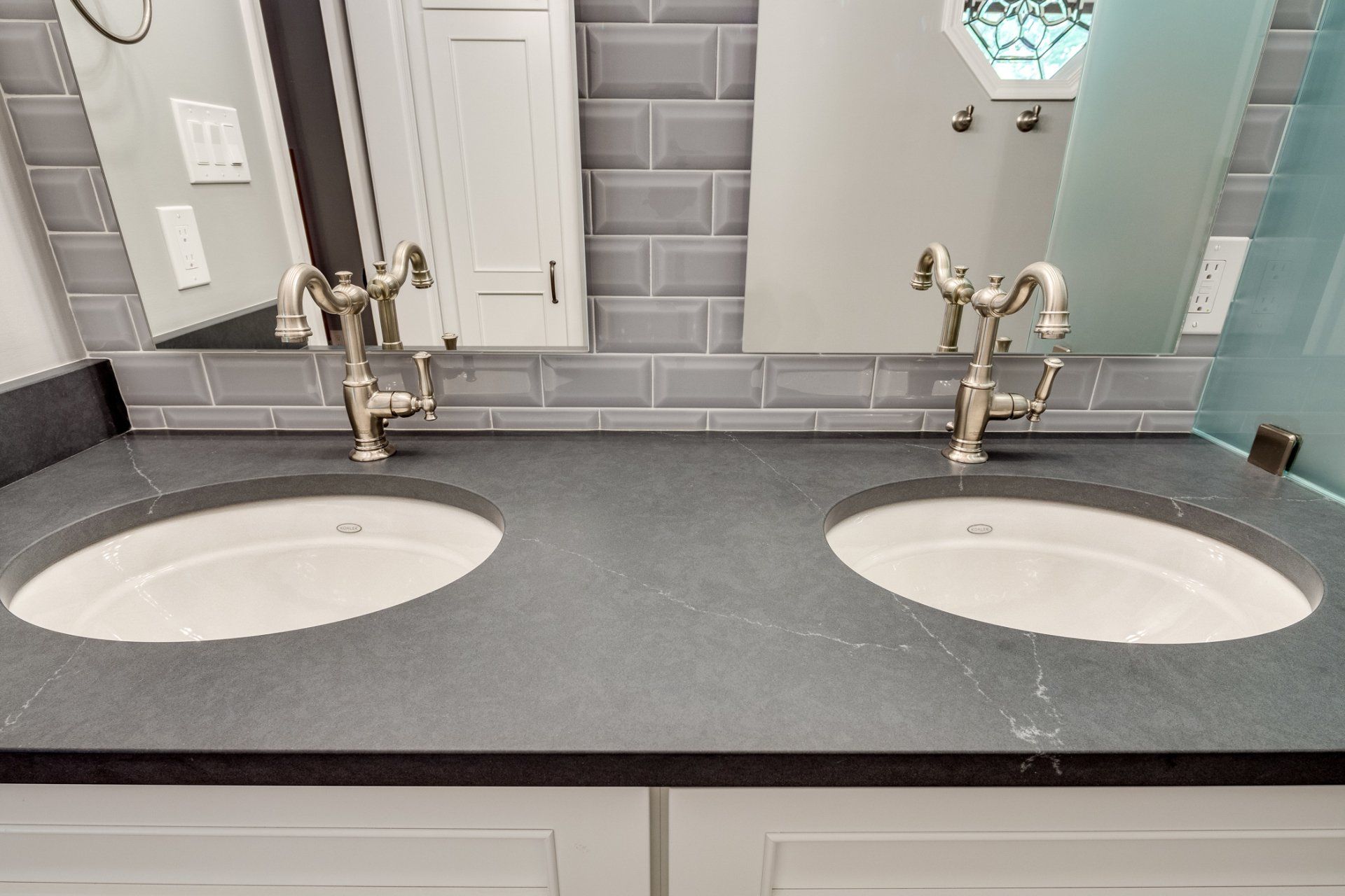 A bathroom with two sinks and a mirror.