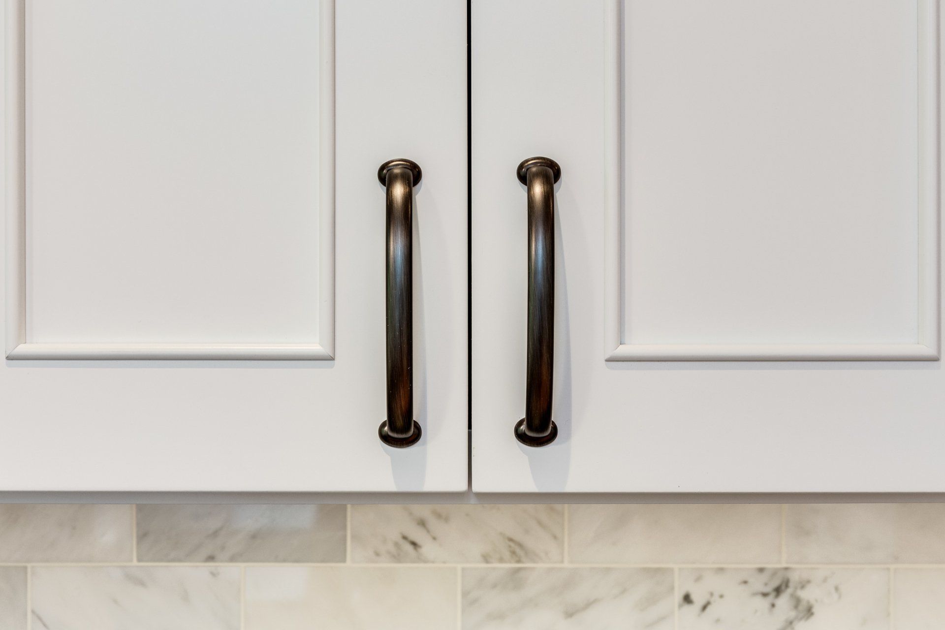 A close up of a kitchen cabinet with brass handles.