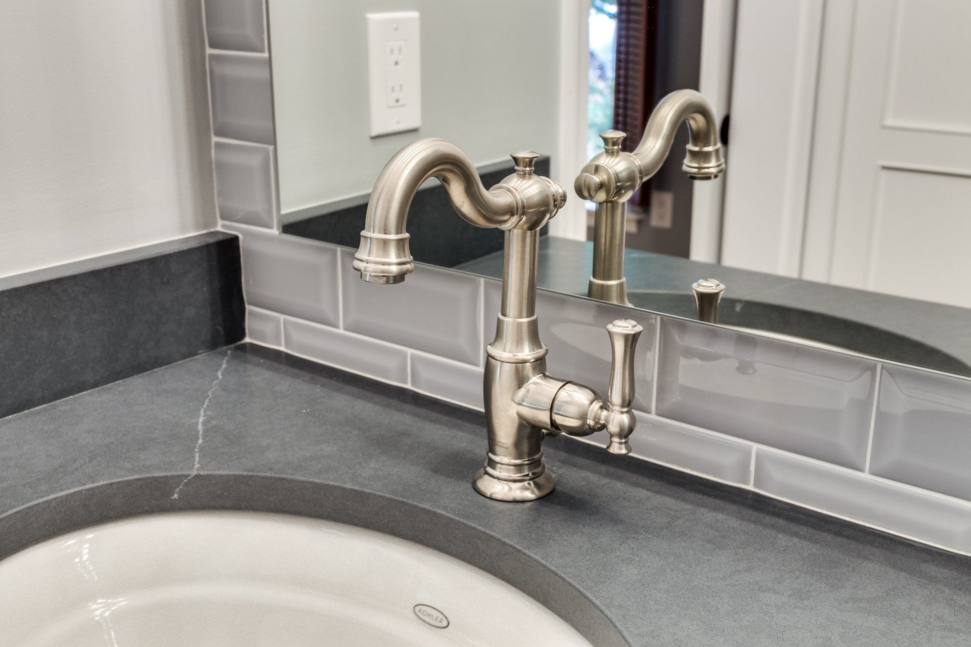 A bathroom sink with a faucet and a mirror