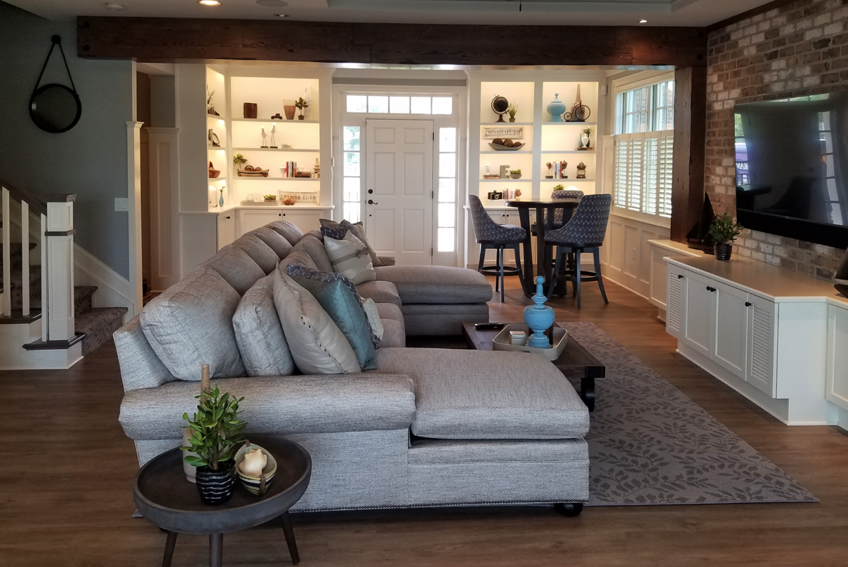 A living room with a large sectional couch and a flat screen tv.