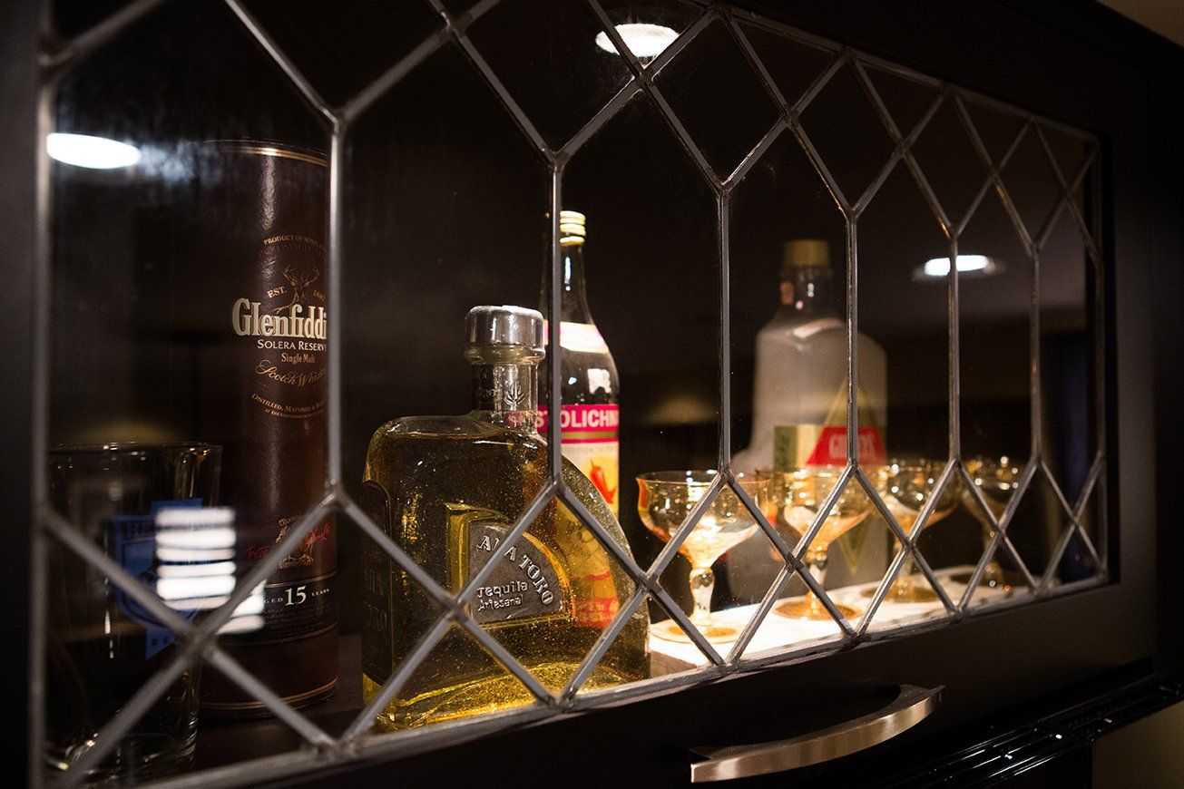 A bottle of glenfiddich is sitting on a glass shelf.