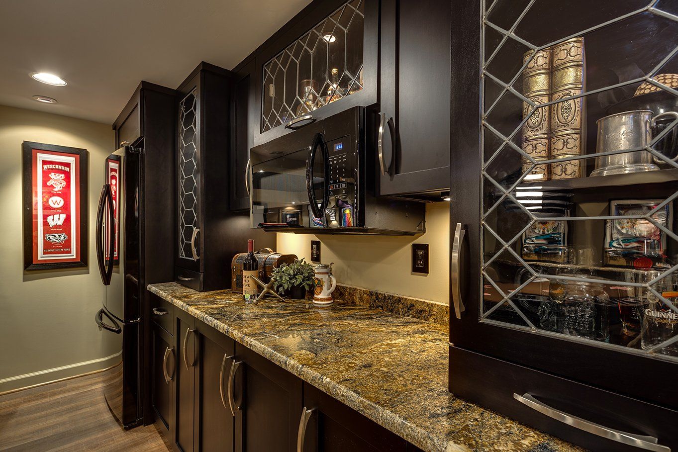 A kitchen with granite counter tops and black cabinets