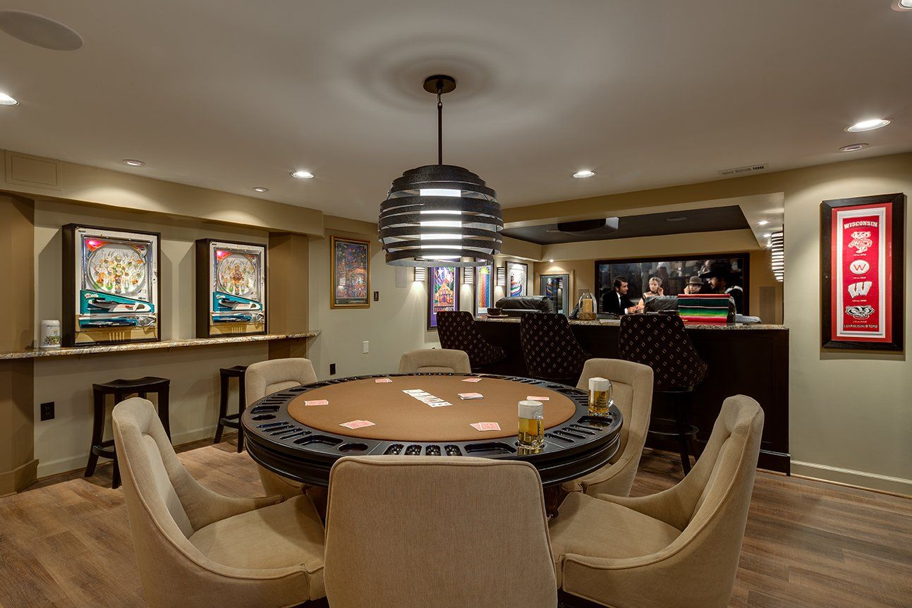 A room with a poker table and chairs in it