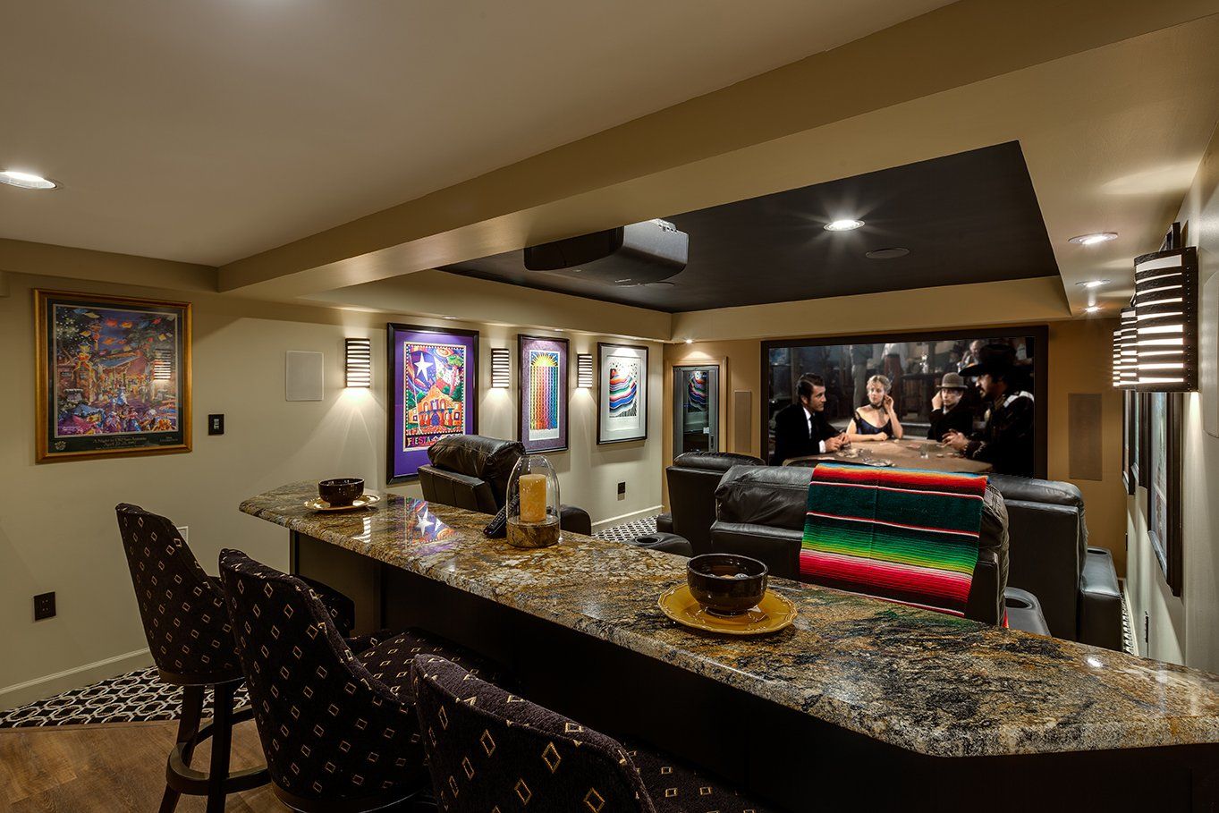 A basement with a bar , chairs , a television and a projector screen.