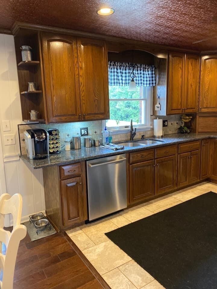 A kitchen with stainless steel appliances and wooden cabinets.