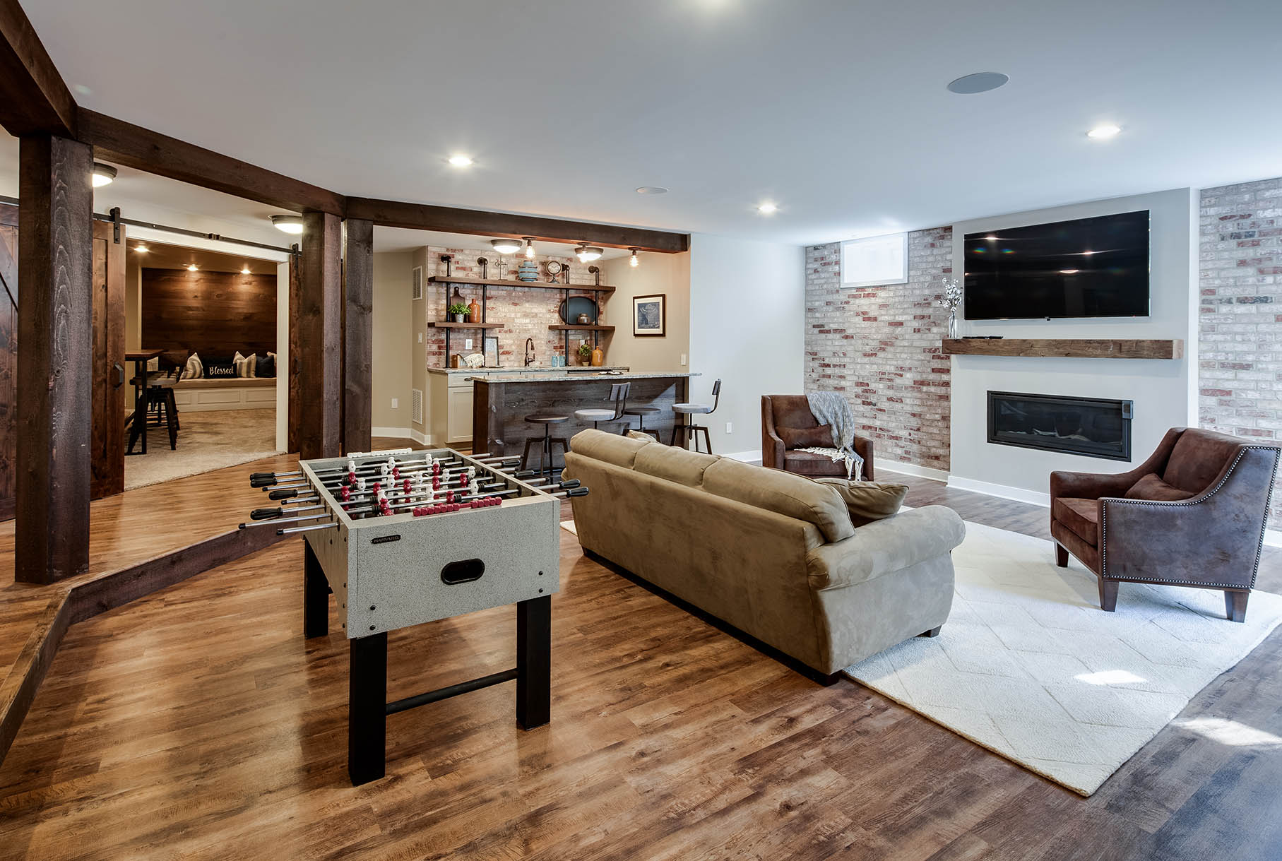 A living room with a foosball table and a couch.
