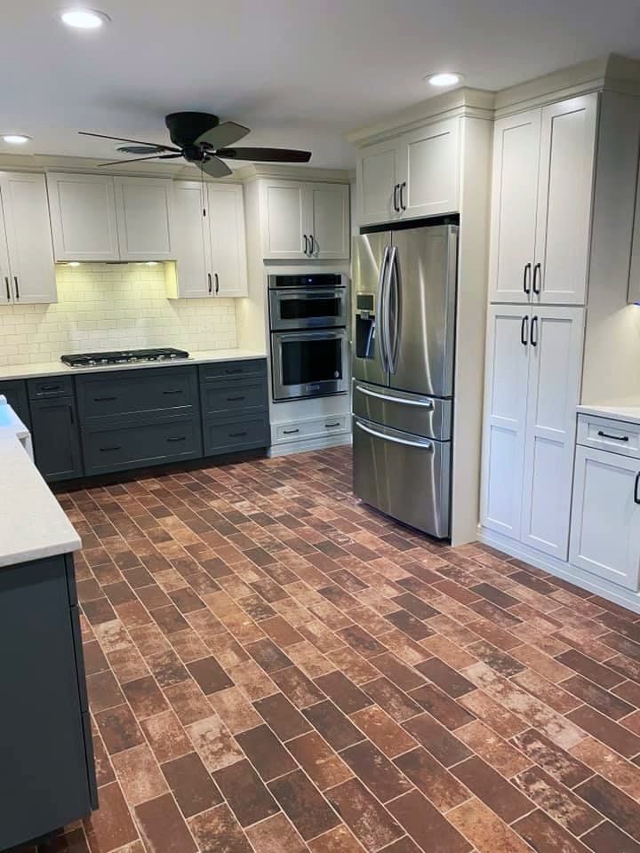 A kitchen with stainless steel appliances and a ceiling fan.